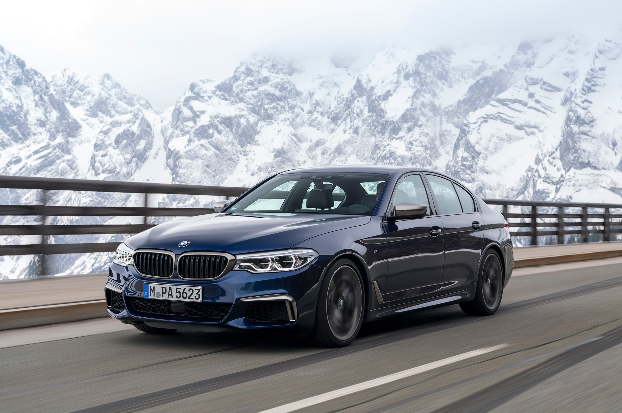 2018-BMW-M550i-xDrive-front-side-motion-view-with-mountains.jpg